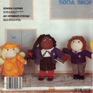 May include: A sewing pattern for making school clothes for 16-inch (40.5 cm) and 18-inch (46 cm) dolls. The pattern includes instructions for making a plaid skirt, a blue blazer, a yellow raincoat, and a blue sweater. The pattern is called "School Clothes" and is from McCall's Crafts.