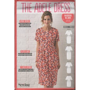 May include: The Adele Dress sewing pattern features a floral print dress with a pleated skirt and kimono-inspired sleeves. The pattern includes two length options and sizes 6-20. The dress has a V-neck and is shown on a woman.