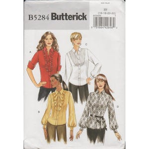 May include: Butterick sewing pattern B5284 for four shirt variations. Includes a red ruffled shirt, a white pleated shirt, a yellow ruffled shirt with long sleeves, and a patterned shirt with a belt. Size FF 16-18-20-22 is printed on the package.