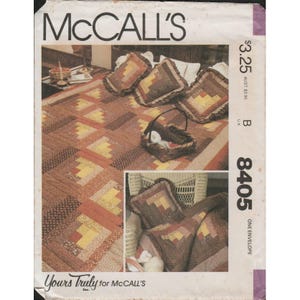 May include: McCall's pattern envelope featuring a quilt and pillow design. The quilt and pillows have a patchwork design in shades of brown, yellow, and orange. The envelope has the text "McCall's" at the top and the pattern number "8405".