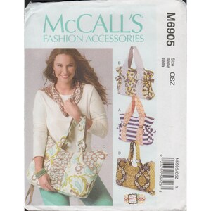 May include: McCall's Fashion Accessories sewing pattern M6905. The pattern features four different tote bag designs. The image shows a woman holding a tote bag with a floral pattern. The pattern includes size OSZ.