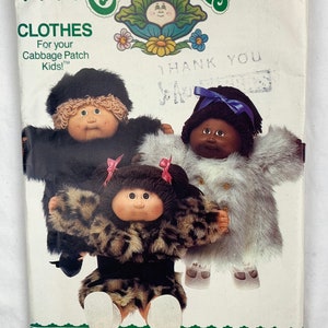 May include: A vintage sewing pattern for Cabbage Patch Kids clothing. The pattern shows three dolls wearing different outfits: a black fur coat, a white fur coat, and a leopard print coat. The pattern is titled "Cabbage Patch Kids" and has the number 6984 printed on it. The pattern is from the company Butterick.