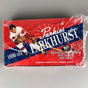 May include: A vintage Parkies Parkhurst hockey card box from 1956-57, wrapped in cellophane. The red box features a hockey player graphic and the Parkhurst logo. The box is labeled "10 Officially Licensed NHL Cards Per Pack."