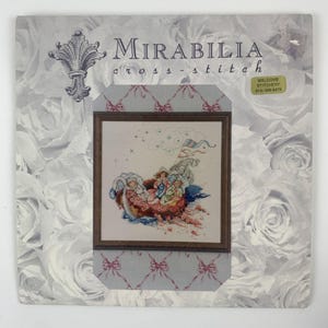 May include: Cross stitch pattern featuring a whimsical illustration of three children riding in a sleigh pulled by a bird. The pattern is titled "Mirabilia cross-stitch" and includes the text "Welcome to Stitchery 818-455-5410".