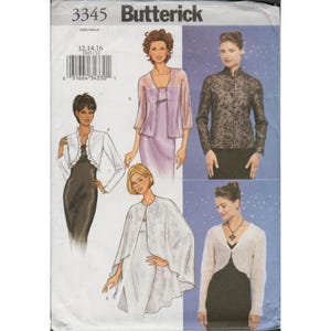 May include: Butterick 3345 sewing pattern envelope featuring illustrations of four different jacket and top styles. The designs include a white ruffled bolero, a lavender sheer jacket over a dress, a black floral print long-sleeve top, and a white cape.