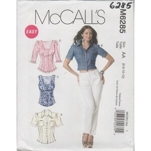 以下が含まれることがあります： McCall's M6285の女性用トップス用縫製パターン。ピンクのフリル付きトップス、青いフローラルトップ、クリーム色のトップス、デニムシャツのオプションが含まれています。サイズはAA（6-8-10-12）です。