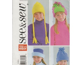 May include: A sewing pattern for four different children's hats. The hats are made of fleece and come in a variety of colors, including yellow, green, blue, and light blue. The pattern includes instructions for making each hat, as well as a list of materials needed. The pattern is titled "See & Sew" and is labeled "4003".