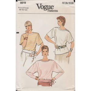 Könnte beinhalten: Vogue Patterns Schnittmuster mit Illustrationen von drei Damenoberteilen. Die Oberteile umfassen ein gestreiftes Kurzarmshirt, ein weißes Kurzarmshirt und ein rosa Langarmshirt. Die Schnittmusternummer ist 8919, Größe 8-10-12.