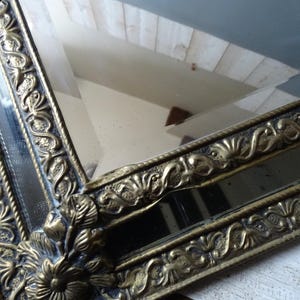 Puede incluir: Un letrero de madera r&uacute;stico blanco con la palabra "Welcome" escrita a mano. El letrero tiene un aspecto envejecido y un elemento floral decorativo. El fondo es una imagen borrosa de una casa.