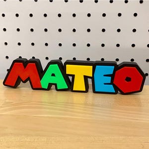 May include: A colorful name sign spelling "MATEO" in black outlined letters. The letters are red, green, yellow, blue, and red.