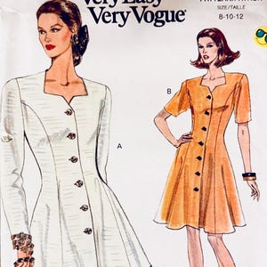 May include: A vintage Very Easy Very Vogue sewing pattern, number 8223, showing illustrations of two dresses. One is white with long sleeves, the other orange with short sleeves. The pattern size is 8-10-12. Measurements are in inches.