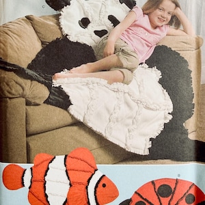 May include: Simplicity fleece throw patterns. The image shows a child on a panda bear fleece throw. Also shown are patterns for a clownfish and ladybug fleece throws. The text "ONE SIZE" is visible.
