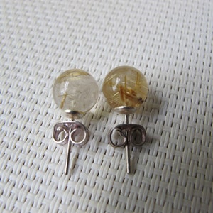 Pode incluir: Um par de brincos de press&atilde;o com pedras preciosas esf&eacute;ricas transparentes com inclus&otilde;es douradas. Os brincos t&ecirc;m pinos prateados e fechos de borboleta. As pedras preciosas t&ecirc;m aproximadamente 1,3 cm de di&acirc;metro.