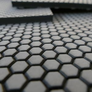 May include: Close-up of a gray, textured surface with a honeycomb pattern.