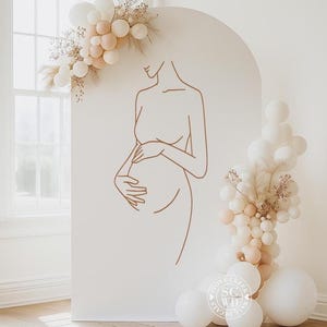 May include: A large, arched, off-white display panel featuring a brown line-art illustration of a pregnant torso. The panel is decorated with clusters of white and beige balloons and dried foliage. A circular logo reads Stone Creek Wall Decals.