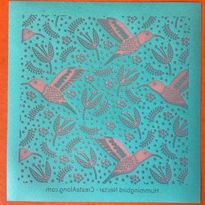 Pode incluir: Um cartão azul turquesa com um padrão repetido de beija-flores cor-de-rosa e flores estilizadas. O texto "Hummingbird Nectar - CreateAlong.com" está impresso na parte inferior do cartão.