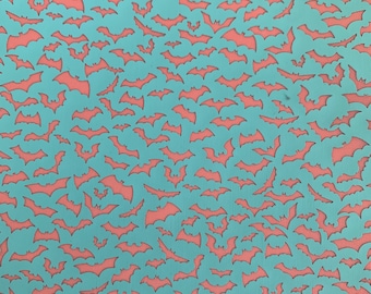 May include: A teal blue background with a repeating pattern of cut-out bats. The bats are all the same size and shape, and they are arranged in a random pattern.