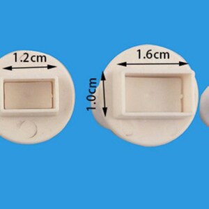 Puede incluir: Cuatro cortadores de galletas de pl&aacute;stico blanco en diferentes tama&ntilde;os. Los cortadores tienen forma de rect&aacute;ngulos con esquinas redondeadas. Los cortadores miden 0,6 cm x 1,0 cm, 0,8 cm x 1,2 cm, 1,0 cm x 1,6 cm y 1,3 cm x 2,1 cm.