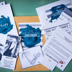 May include: A set of game materials for a New Year's Eve escape room game. The materials include a blue and white striped card with the text "The New Year's Ball Escape Room Game", a white card with the text "Hints", a white card with the text "Employee #47563", a white card with the text "Speeding Ticket", a white card with the text "The Yo Times", and a white card with the text "Be the Leader, the Rest We Thief".