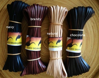 May include: Four spools of leather cord in different colors: navy, brandy, natural, and chocolate. Each spool is wrapped with a rubber band and has a label with the color name and the text "Leatheroo.com".