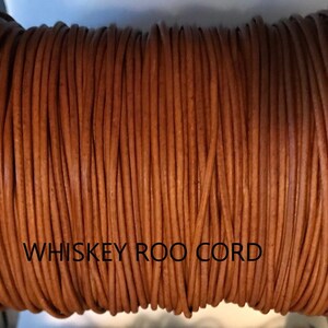 May include: A spool of brown leather cord labeled "WHISKEY ROO CORD".