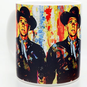 Pu&ograve; includere: Una tazza in ceramica bianca con un'immagine colorata di un uomo con un cappello da cowboy che tiene una pistola. Lo sfondo &egrave; un design astratto colorato.