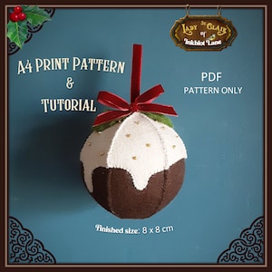 Pode incluir: Um enfeite de Natal de feltro em forma de pudim com cobertura branca e granulado dourado. O enfeite tem 8 cm de diâmetro e vem com um padrão imprimível e um tutorial.
