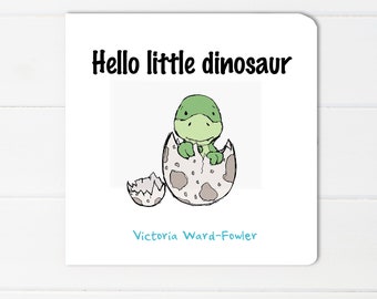 Puede incluir: Un dinosaurio verde saliendo de un huevo moteado. El texto "Hello little dinosaur" está por encima del dinosaurio y "Victoria Ward-Fowler" está debajo del dinosaurio.