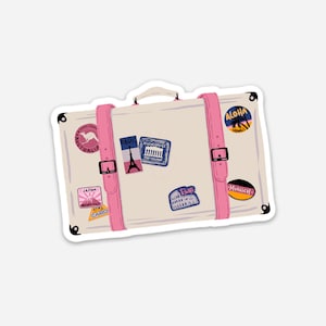 May include: A vintage-style white suitcase with pink straps and various travel stickers. The stickers feature destinations like "Japan", "Rome", "Munich", "Aloha Hawaii", "Athens Greece", "Paris", "Cairo", and "Australia".
