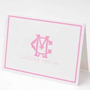 Puede incluir: Una tarjeta blanca con un borde rosa y un monograma rosa de las letras "CM" en una fuente decorativa. El texto "CAROLINE MINEART" está impreso debajo del monograma.