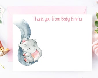 May include: A white thank you card with a pink border. The card features a watercolor illustration of a baby elephant with its trunk wrapped around a larger elephant. The text "Thank you from Baby Emma" is printed in pink at the top of the card.