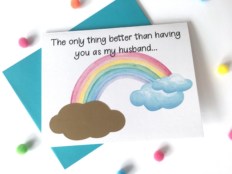 May include: A white card with a rainbow and clouds illustration. The text on the card reads "The only thing better than having you as my husband..."
