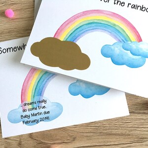 May include: A white card with a rainbow and clouds painted on it. The text "...dreams really do come true. Baby Martin due February 20191" is written on the card.