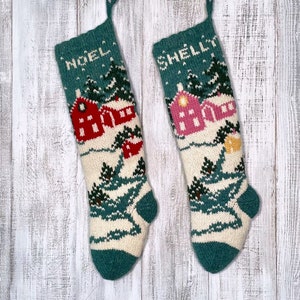 Puede incluir: Dos calcetines de Navidad tejidos con un diseño de escena de invierno. Un calcetín dice "NOEL" y el otro dice "SHELLY".