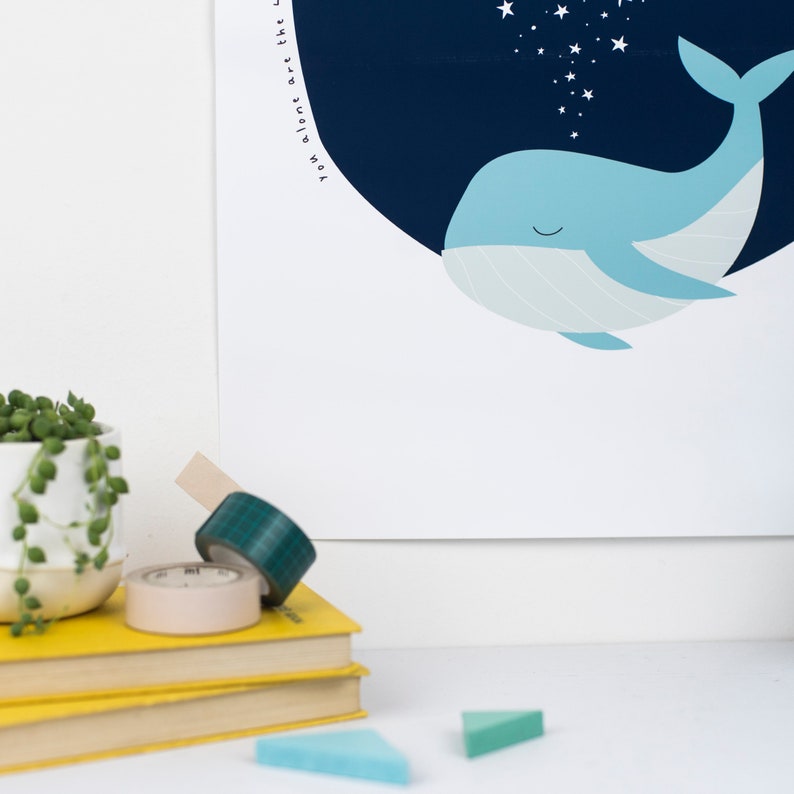 May include: A whimsical illustration of a light blue whale with a dark blue background and white stars. The text "You alone are the light" is written in a curved line. Decorative tape rolls and a succulent plant in a white pot are in the foreground.