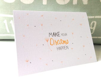 Może przedstawiać: Biała kartka z jasnoszarym, teksturowanym tłem. Na kartce znajduje się wzór jasnopomarańczowego mlecza i napis "MAKE YOUR DREAMS HAPPEN".
