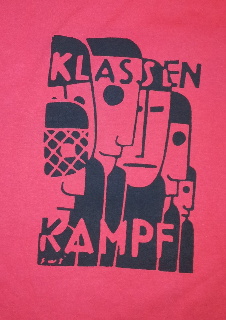 May include: Black and white graphic print on a red t-shirt. The print features three stylized faces and the text "KLASSENKAMPF".