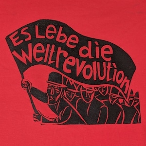 May include: A red t-shirt with a black print of a group of people holding a banner that reads "Es Lebe die Weltrevolution".