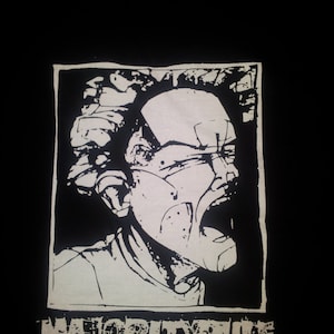 Puede incluir: Camiseta gráfica en blanco y negro con una cara gritando y el texto "Majority Rule" impreso en la parte delantera.