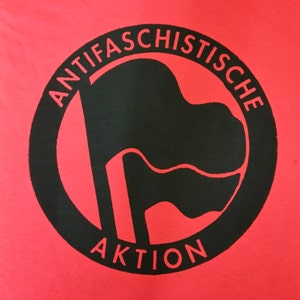 May include: A red t-shirt with a black circle containing a black flag and the text "ANTIFASCHISTISCHE AKTION".