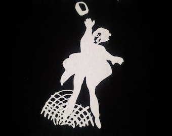May include: A black t-shirt with white text that reads "LA BEAUTÉ EST DANS LA RUE". The design features a silhouette of a person throwing a ball in the air.