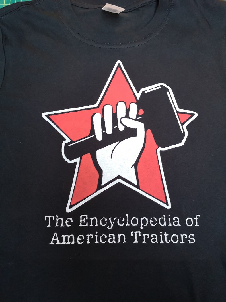 May include: Black t-shirt with a red star and a white fist holding a hammer. The text "The Encyclopedia of American Traitors" is printed below the star.