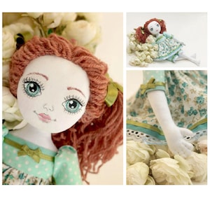 May include: A handmade doll with red yarn hair, a white face with painted features, and a green and white floral dress. The doll is sitting on a bed of white flowers. The image includes the text "Taya Toy Barefooted Doll" and "Tutorial and Pattern".