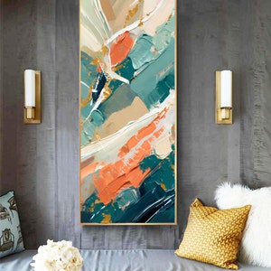 Può includere: Dipinto astratto con cornice dorata. Il dipinto presenta una miscela di colori turchese, pesca e beige con accenti dorati. I colori sono applicati con pennellate spesse e testurizzate.
