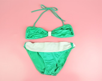 Könnte beinhalten: Ein grüner Bikini mit weißem Saum am Unterteil. Das Oberteil ist ein Bandeau-Stil mit einem Halfterriemen.