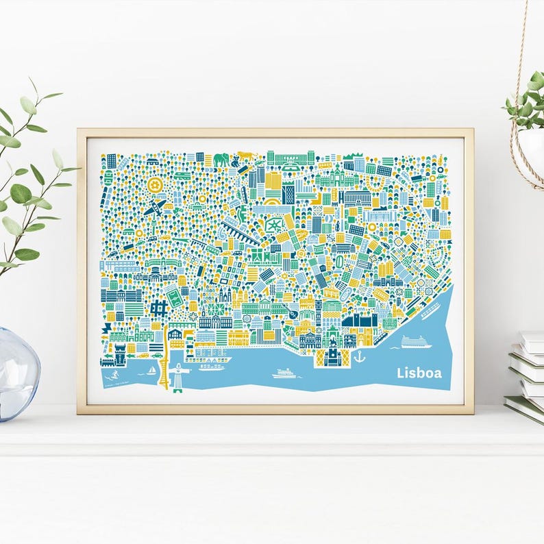 May include: A framed art print of a map of Lisbon, Portugal, in a colorful, stylized illustration. The map features buildings, landmarks, and water in shades of blue, green, and yellow. The word "Lisboa" is printed in white at the bottom.