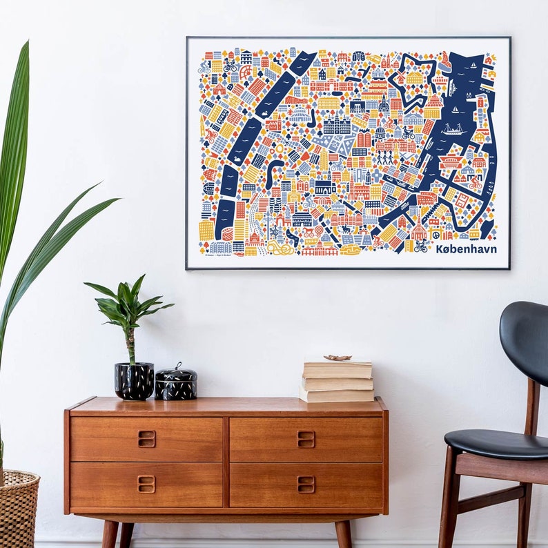Pu&ograve; includere: Una mappa illustrata colorata di Copenaghen, Danimarca, con una cornice nera, appesa a un muro bianco sopra una cassettiera in legno con quattro cassetti. La mappa &egrave; in stile minimalista con una combinazione di colori blu, giallo e rosso. La parola "Kobenhavn" &egrave; stampata in nero nella parte inferiore della mappa.
