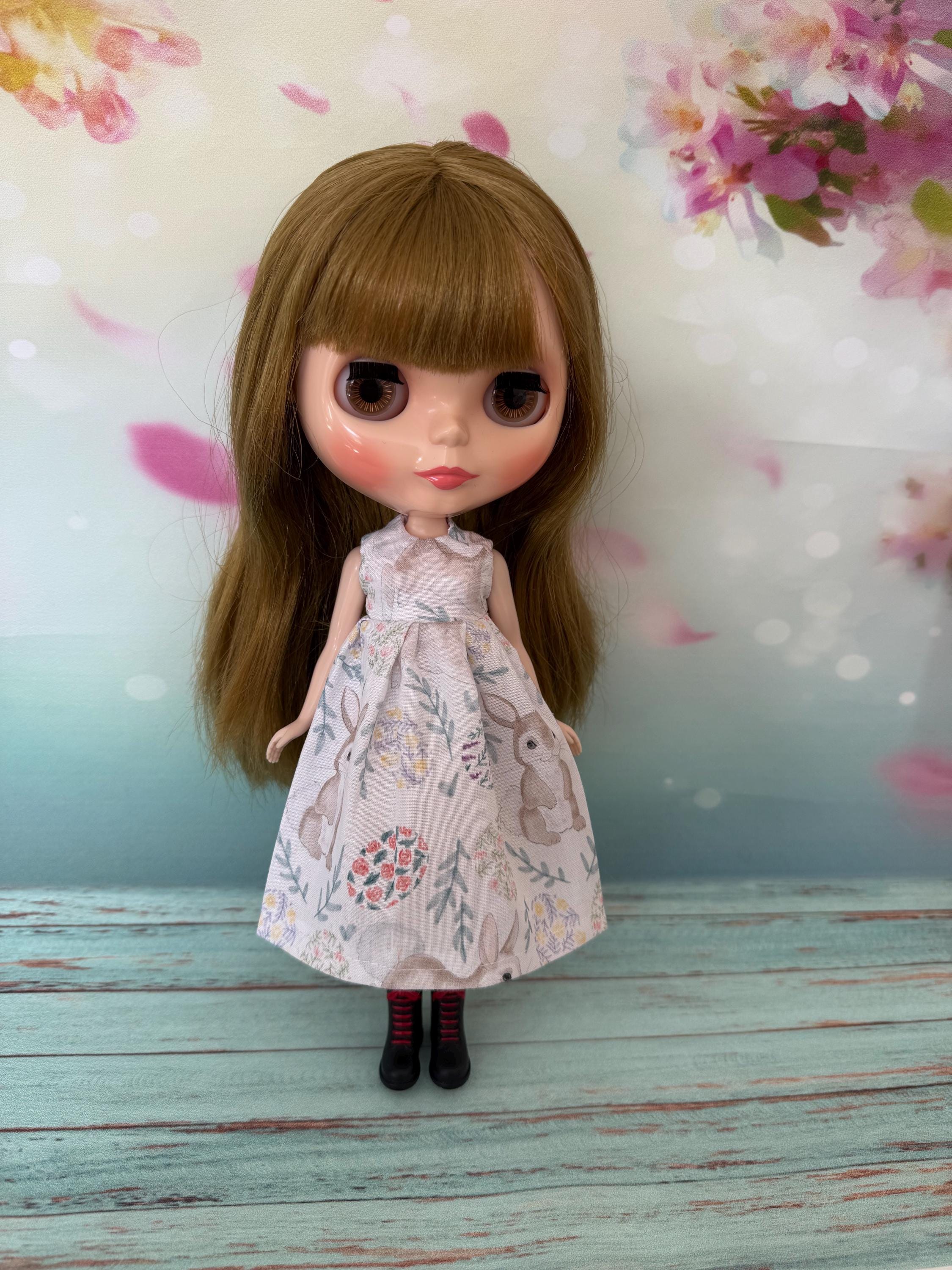 イースターギフトとしてのデザイナー人形 花柄ドレスの伝統的な人形 イースターエッグとウサギのプリントが入った白いドールドレス