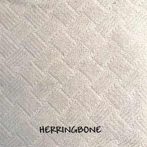 Closeup of the herringbone weave pattern in our soft, natural colored cotton throw blanket.  All blankets come with custom personalization and make wonderful elegant and cozy gifts.
