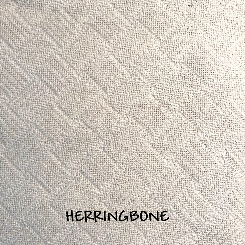 Closeup of the herringbone weave pattern in our soft, natural colored cotton throw blanket.  All blankets come with custom personalization and make wonderful elegant and cozy gifts.